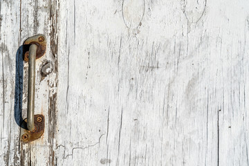 Wooden texture background. Old wood texture with white peeling paint. Different vertical lines. Old door knob to the left side. Background for text or design