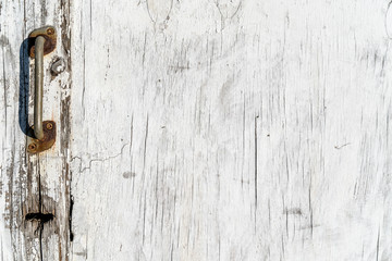 Wooden texture background. Old wood texture with white peeling paint. Different vertical lines. Old door knob and keyhole to the left side. Background for text or design