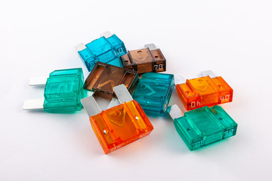 Maxi blade fuses with different ampers on isolated white backgrounds. Electric car parts.