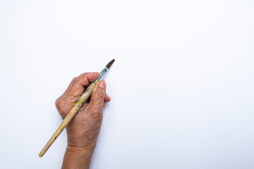 Senior woman's hand painting with paintbrush isolated on white background