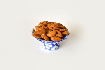 Almonds in a blue porcelain bowl an abstract background