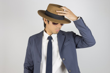 Young Asian Portrait Businessman in Navy Blue Suit Wear Sunglasses and Touch Top of Hat