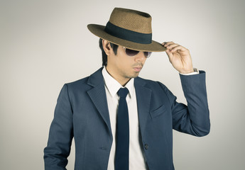 Young Asian Portrait Businessman Wear Sunglasses and Hat at Front View in Vintage Tone
