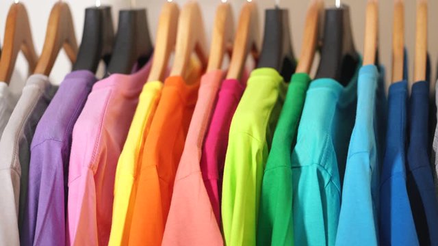 Close up of Colorful t-shirts on hangers, apparel background