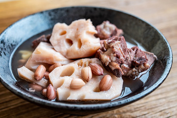 A bowl of lotus root peanut soup on a wooden table