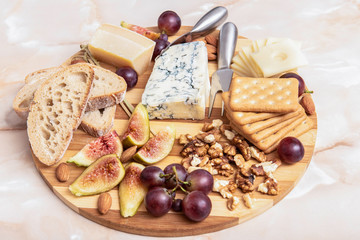 cheese plateau with nuts, grapes, figs, almonds and bread