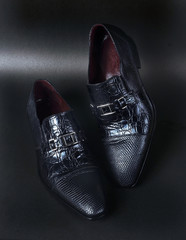 Black duel textured men shoes on black ground