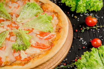 Pizza with herbs, cheese and tomatoes