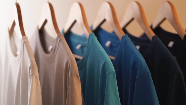 Close up of Colorful t-shirts on hangers, apparel background