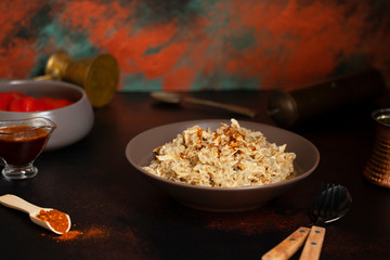 Traditional for Turkish, Greek and Iranian cuisine, a dish called Keskek. Served with pickled red peppers, butter and paprika powder. Front view, copper background, copyspace