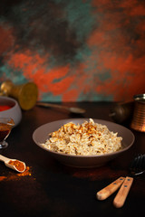 Traditional for Turkish, Greek and Iranian cuisine, a dish called Keskek. Served with pickled red peppers, butter and paprika powder. Front view, copper background, copyspace