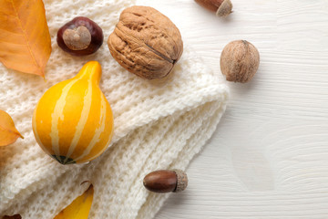 Autumn composition with decorative pumpkins and yellow leaves and a warm scarf. autumn time. on a white wooden table. view over...