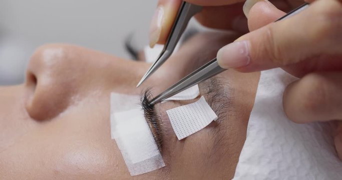 Woman having eye lash extension process