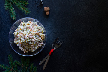 Traditional Russian New Year and Christmas salad of vegetables, meat and mayonnaise called Olivier. Russian salad. Top view. Dark background. Copyspace