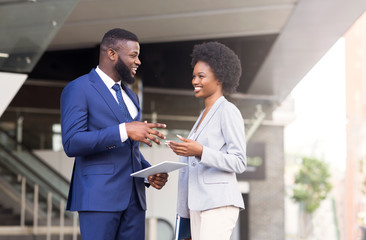 Handsome black man telling joke to his female colleague