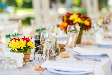 Wedding table set up decoration made of red and yellow fresh flowers. Rustic/ garden wedding decoration