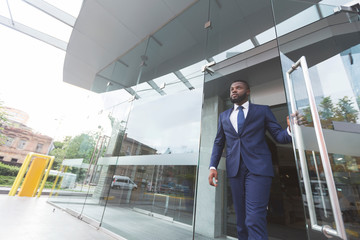 Handsome african american ceo leaving business center after meeting