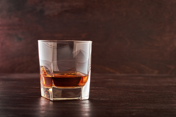 One glass of whiskey on a wooden table