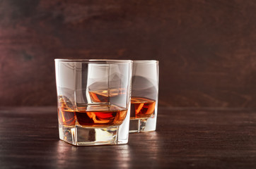 Two glasses of whiskey on a wooden table
