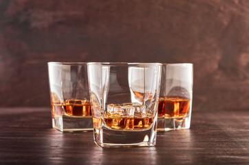 Three glasses of whiskey on a wooden table