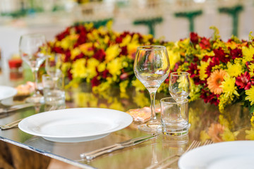 Wedding table set up decoration made of red and yellow fresh flowers. Rustic/ garden wedding decoration