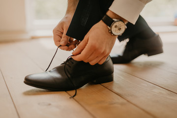 Groom Tying His Shoes on the wedding day. Black and white image