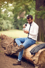 Naklejka na ściany i meble coffee break from job - businessman sitting and resting at park..