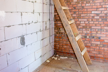 Wooden ladder against a brick wall