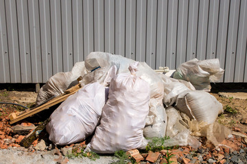 Bags of construction waste lying in a pile in the yard