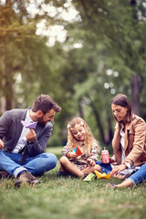 Fototapeta premium daughter with their business mother and father sitting and resting at park..