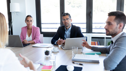Business people discussing together in conference room during meeting at office.