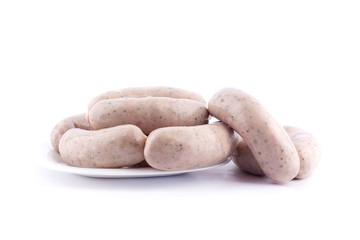 homemade pork sausages with spices in a plate on a white background isolated
