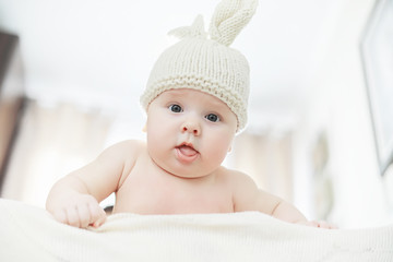 A newborn baby is lying on a soft bed.