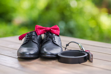 Groom's accessoriers for a wedding - shoes, cloth, bow tie, watch and a leather belt . 