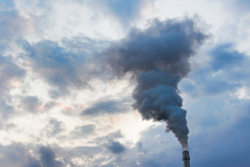 Pipe of a production factory with cloudy fumes smoke emission into the atmosphere on the background...