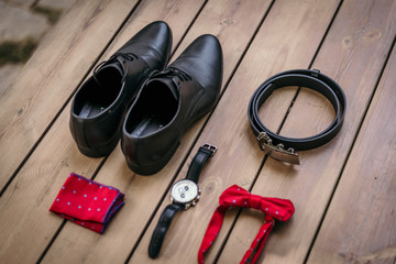 Groom's accessoriers for a wedding - shoes, cloth, bow tie, watch and a leather belt . 