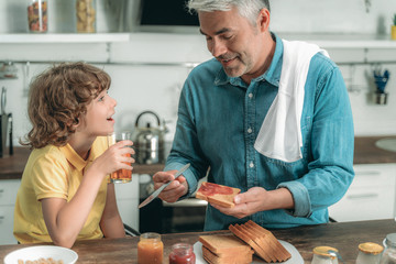 Happy father and little kid making breakfast
