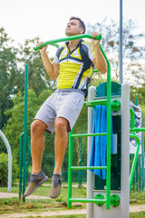 Man doing pull ups in outdoor gym