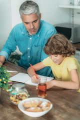 Father and son making school homework at home