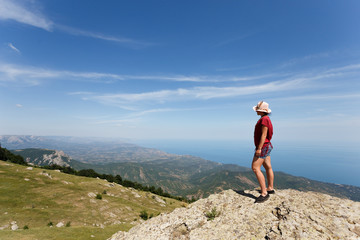 Traveller on a top of mountain, cloud sky background.
