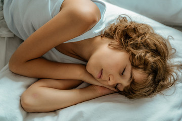 Little boy sleeping in bed at morning