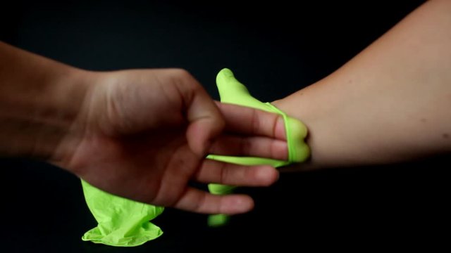 Hands of doctor surgeons and assistants with ophtalomological surgery tools during surgical treatment. Indoor. Close up. Doctor wears green gloves.