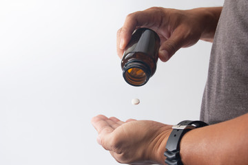 man take madicine pill from bottle to hand