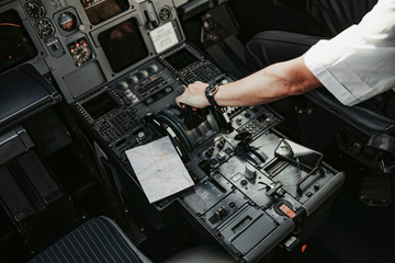 Male hand accelerating on throttle in cockpit of aiplane