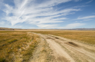 Fototapeta na wymiar Wildlife Altai. The road, mountains and sky with clouds in summer