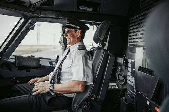 Happy pilot in cockpit looking through window