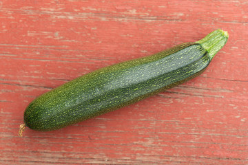 Homegrown green zucchini on old red vintage table