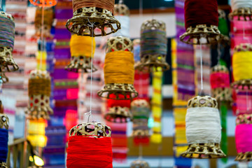 Closeup decorative wicker lantern and Lanna fabric long flags (TUNG) hang on hotel lobby ceiling and blurry background.