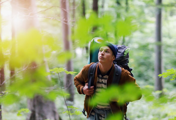 Naklejka na ściany i meble Tourist man traveler hiking in the mountains with large tourist backpack