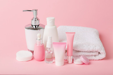 Face and body care products with spring bloom (tonic or lotion, serum, cream, shampoo, micellar water, cotton pads and sticks, shaver) on pink. Freshness and body care. Skin cosmetics. Border banner